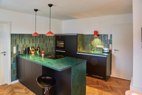 una cucina con armadi neri e piastrelle verdi di Klimatisierte Wohnung mit großer Terrasse a Deidesheim