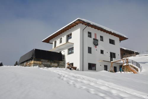 un bâtiment dans la neige avec des empreintes de pied dans la neige dans l'établissement Appartement Wieshof, à Neukirchen am Großvenediger