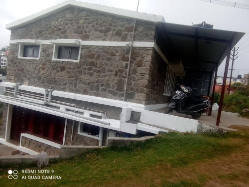 een gebouw met een motor die ervoor geparkeerd staat bij KODAIKANAL HOME STAY in Kodaikānāl