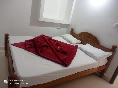 een rode handdoek bovenop een bed bij KODAIKANAL HOME STAY in Kodaikānāl