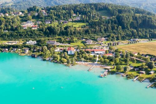 una vista aerea di un resort sulla riva di un lago di Strandhotel Faak a Faak am See