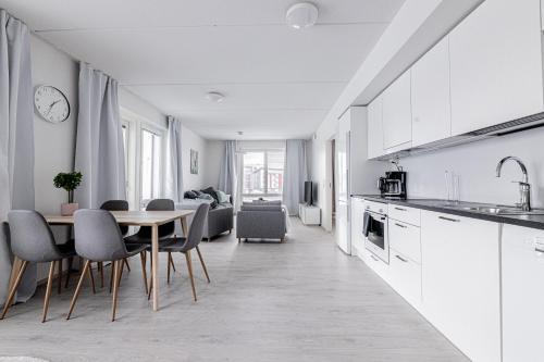 una cucina e una sala da pranzo con tavolo e sedie di Apartment, SleepWell, Nuutti a Turku