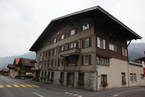 un grand bâtiment en bois sur le côté d'une rue dans l'établissement Boutique Hotel & Restaurant Bären Ringgenberg, à Ringgenberg