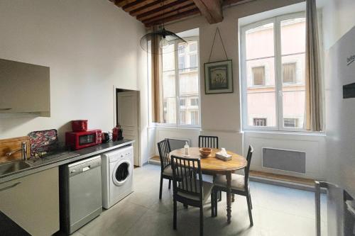 una cucina con tavolo e sedie in una stanza di Coeur Vieux Lyon, 60 M2 lumineux tout confort a Lione