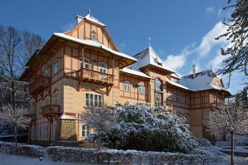 un grand bâtiment avec un balcon dans la neige dans l'établissement Jestřabí, à Luhačovice