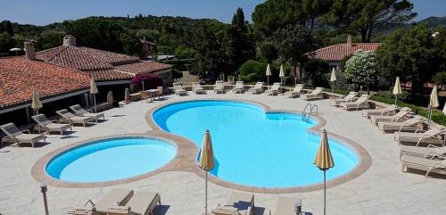 una gran piscina con tumbonas y sombrillas en Hotel Nibaru, en Porto Cervo