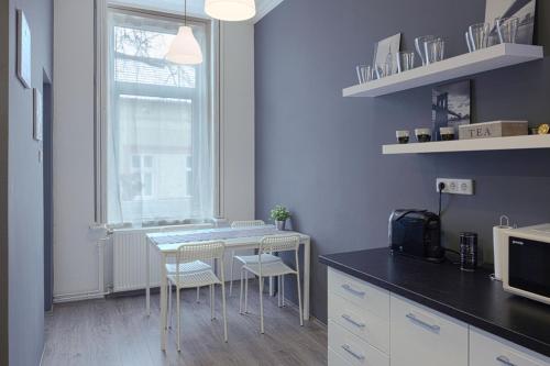 une cuisine avec une table et des chaises ainsi qu'une fenêtre dans l'établissement HEMNES Apartman, à Kaposvár