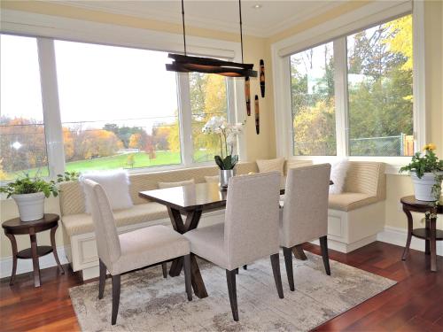 een eetkamer met een tafel, stoelen en ramen bij iResidence in Toronto - Unique Mansion - Fantastic Views in Toronto