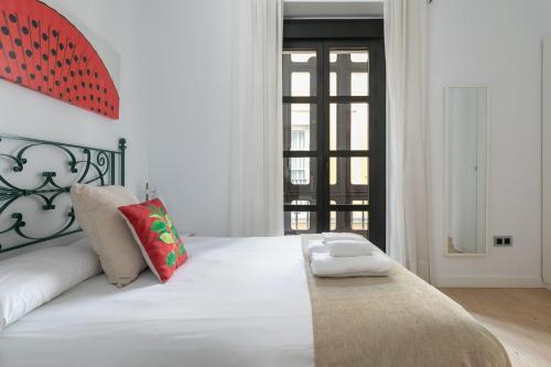 a white bedroom with a large white bed with pillows at Holiday Rentals Tempa Museo in Seville