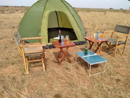 dwa stoły i krzesła przed namiotem w obiekcie Amanya Double Pitch Tent with Mt Kilimanjaro View w mieście Amboseli