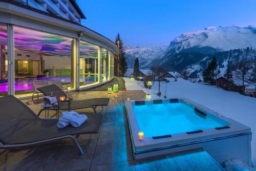 a house with a swimming pool in the snow at Hotel Waldegg - Adults only in Engelberg