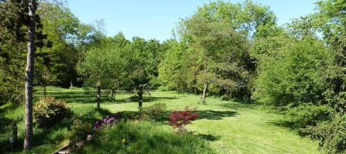 a garden with trees and grass and flowers at LA CHERIELLE in Auvers-sur-Oise