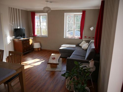 sala de estar con sofá azul y 2 ventanas en Ferienwohnung am Spreeradweg in Bautzen, en Bautzen