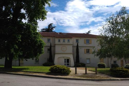 ein großes Gebäude mit einem Baum davor in der Unterkunft Chambre d'hôte Sainte Émilie in Annonay