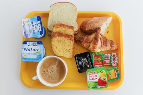 une assiette jaune avec du pain grillé et une tasse de café dans l'établissement Premiere Classe Thionville - Yutz, à Yutz