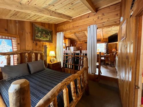 - une chambre avec un lit dans une cabane en rondins dans l'établissement Pine Haven Resort, à Estes Park