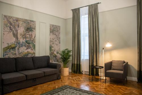 uma sala de estar com um sofá e uma cadeira em Allegro apartments city center em Oradea