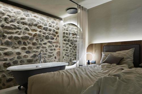 a bedroom with a bed and a bath tub and a sink at Truma Swing Luxury in Merano