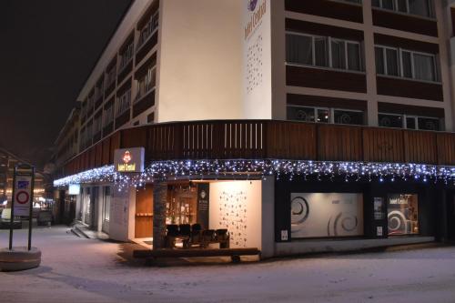 een gebouw met kerstverlichting aan de zijkant bij Hotel Central, Spa & lounge bar in Crans-Montana