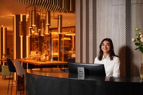 una donna seduta a un tavolo con un portatile di Best Western Plus Congress Hotel Yerevan a Yerevan