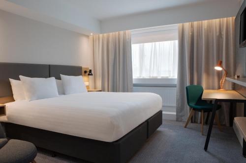 una camera d'albergo con letto e scrivania di Holiday Inn Bolton Centre, an IHG Hotel a Bolton