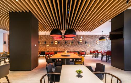 een restaurant met tafels en stoelen en een bakstenen muur bij Holiday Inn Express Melbourne Little Collins, an IHG Hotel in Melbourne