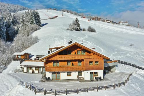 una casa su una montagna innevata con una recinzione di Residenz Erschbaum a Valdaora