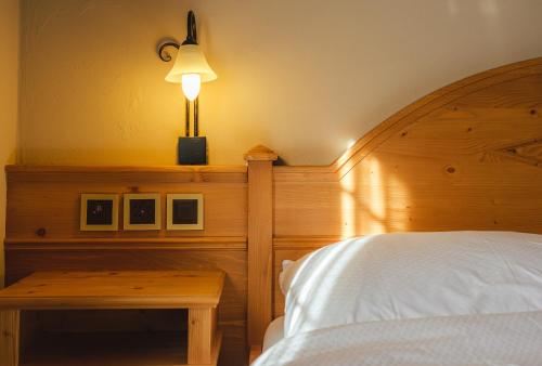 una camera con letto e tavolo con lampada di Guesthouse by the rex a Zermatt