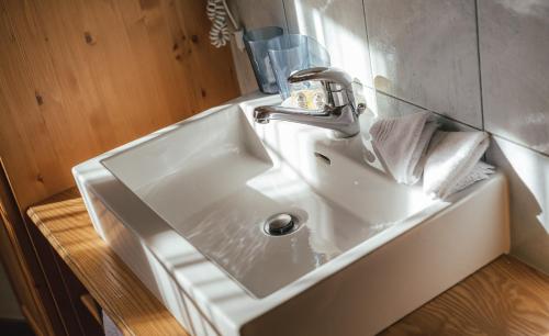 un lavandino bianco in un bagno con specchio di Guesthouse by the rex a Zermatt