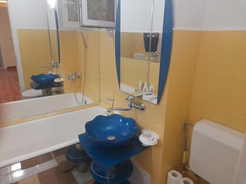 y baño con aseo azul y bañera. en New 33, en Bacău