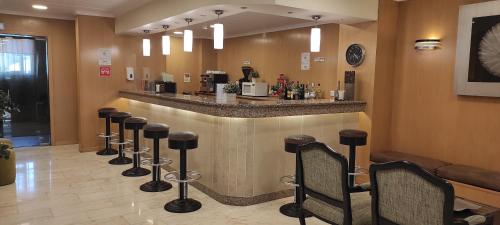 a bar with a row of bar stools in a room at Hotel Sao Mamede in Estoril