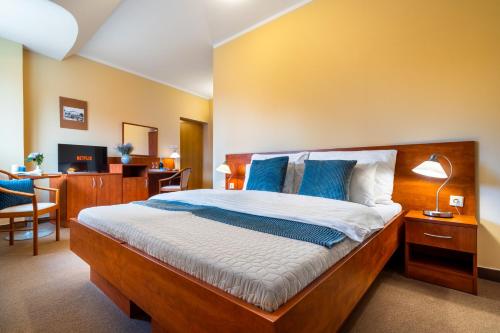 a bedroom with a large bed with blue pillows at Hotel U Vlašského Dvora in Kutná Hora