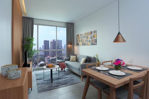 a living room with a table and a couch at Citadines Sudirman Jakarta in Jakarta