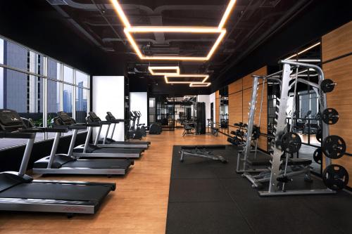 a gym with a row of treadmills and machines at Citadines Sudirman Jakarta in Jakarta