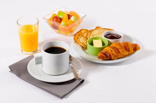 a cup of coffee and a plate of breakfast food at Campanile Hotel Chantilly in Chantilly