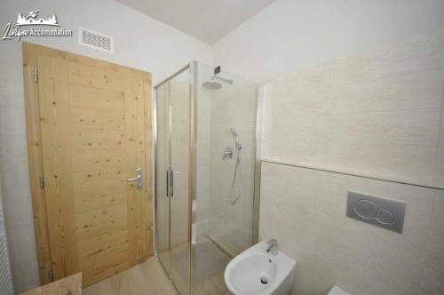 een badkamer met een douche en een toilet met een glazen deur bij Al Bait da Valeriano by Livigno Accomodation in Livigno