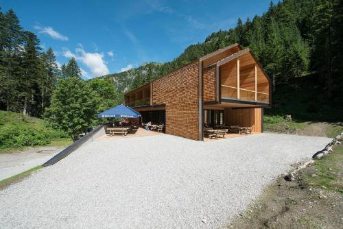 ein Haus auf einem Hügel mit großer Auffahrt in der Unterkunft Vallesinella Hotel Restaurant Bar in Madonna di Campiglio