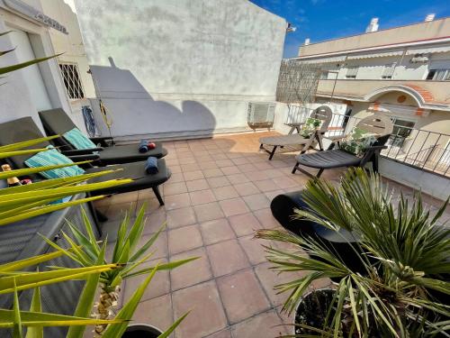 un patio avec des chaises et des plantes dans un bâtiment dans l'établissement Sea Dreams with Amazing Terrace, à Sitges