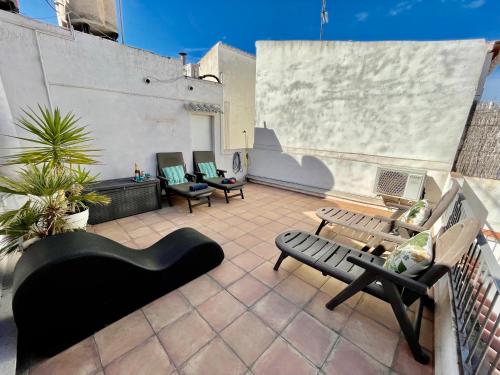 d'une terrasse sur le toit avec des bancs et des chaises. dans l'établissement Sea Dreams with Amazing Terrace, à Sitges