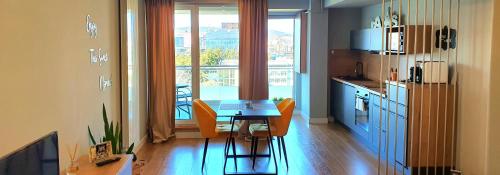 una cucina con tavolo e sedie in una stanza di Eriss Studio Suite - OZone building apartment a Cluj-Napoca