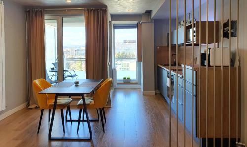 una cucina con tavolo, sedie e frigorifero di Eriss Studio Suite - OZone building apartment a Cluj-Napoca