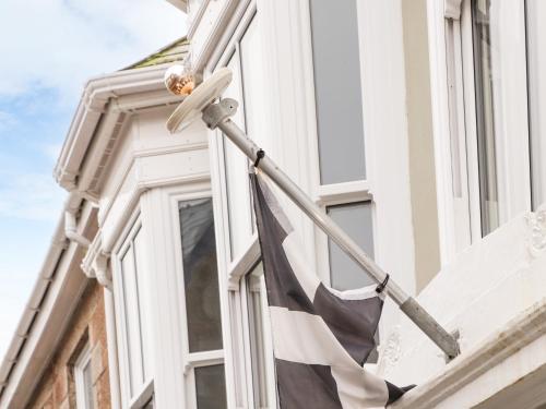 a flag on the side of a building with a window at Battell Chambers in Camborne