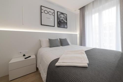 una camera bianca con un letto e un asciugamano sopra di Apartamento Logroño Avenida Ayuntamiento a Logroño