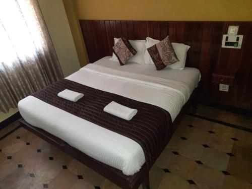 - une chambre avec un grand lit et 2 oreillers dans l'établissement HOTEL CAVERI COMFORT INN, à Madikeri