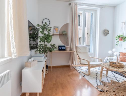 un soggiorno bianco con scrivania e sedia di Appartement 1er étage piéton Place de la Pierre a Valence