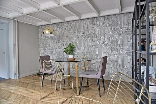 een eetkamer met een tafel en stoelen bij Loft Royal des Promenades in Reims