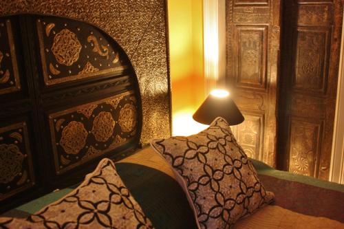 Moroccan Boutique Guest House في بوسطن: غرفة نوم بسرير ومخدة ومصباح