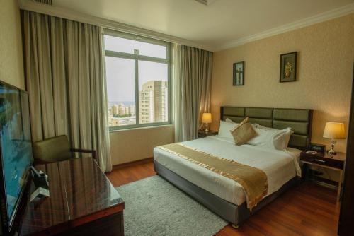 una camera d'albergo con un letto e una grande finestra di City Tower Hotel a Kuwait