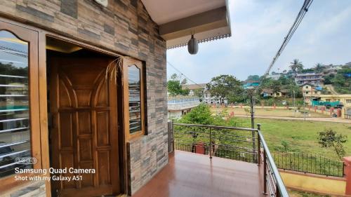 Camera con balcone affacciato su un campo. di Varam Homestay a Madikeri