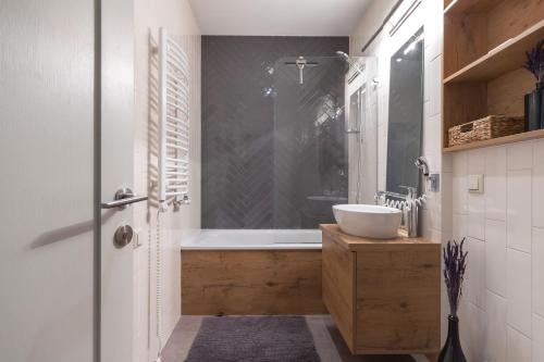 a bathroom with a sink and a bath tub at Pilies Street Exclusive Apartment by Reside Baltic in Vilnius